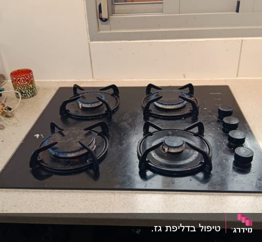 כיריים גז על משטח מטבח עם כלים